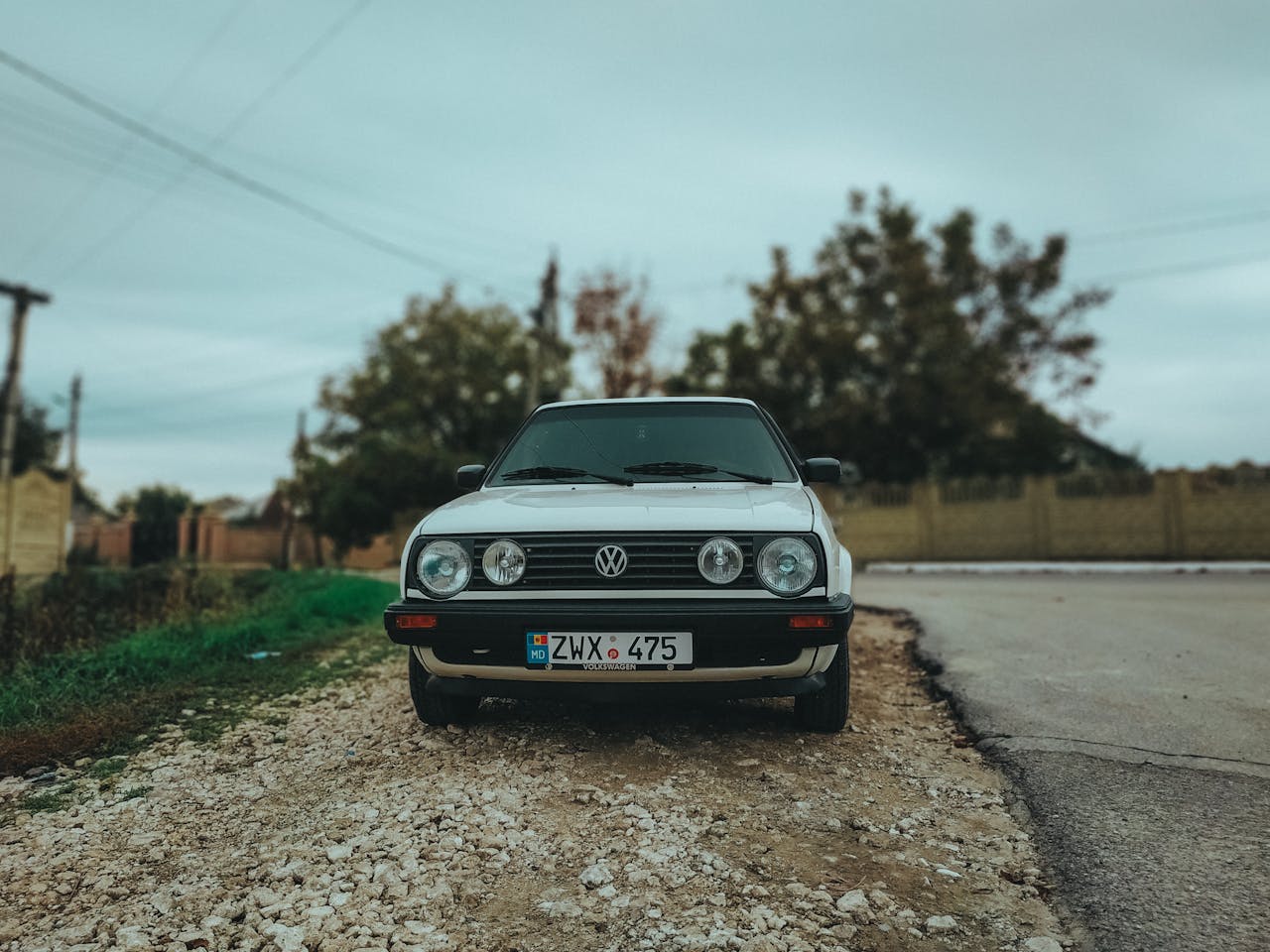 Front view of a classic Volkswagen Golf Mk2 parked on a rural Moldova roadside.